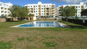 a swimming pool in a yard with buildings in the background at Apartamento Urb. Vila Nova, Lote 5 in Armação de Pêra