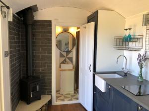 a kitchen with a sink and a stove at Purbeck Shepherd Huts in Worth Matravers