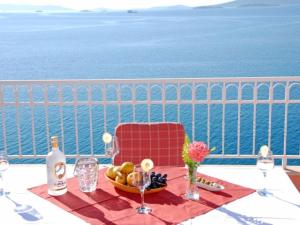 a table with a bowl of fruit and wine glasses at Apartments Lucija in Seget Vranjica