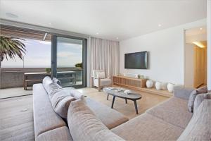 sala de estar con sofá y mesa en Waters Edge 101, en Ciudad del Cabo