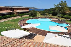 een zwembad met parasols en een resort bij Cala Paradiso Residence in San Teodoro