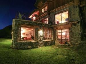 a large stone house at night with lights at Le Chalet des Anges in Sainte-Foy-Tarentaise