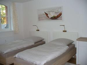 two beds in a room with a picture on the wall at Ferienwohnung Riedner in Lüneburg