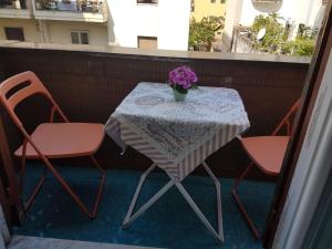 a table with two chairs and a vase of flowers on a balcony at B&B Villa Italia in Salerno