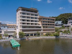 a green table in the water in front of a building at Sansuikan Kinryu in Hamamatsu