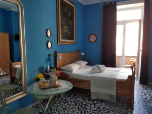 ein blaues Schlafzimmer mit einem Bett und einem Spiegel in der Unterkunft B&B Villa Italia in Salerno