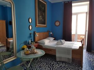 una camera blu con letto e specchio di B&B Villa Italia a Salerno
