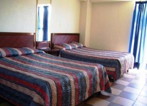 a hotel room with two beds with striped blankets at Hotel Don Pedro Centro in Villa de Tamazulapan