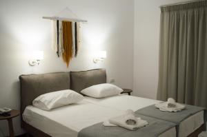 a bedroom with a bed with two towels on it at Paradise Beach Hotel in Argasi