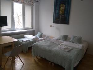 ワルシャワにあるStudio Iwickaのデスク、デスクが備わる客室のベッド2台分です。