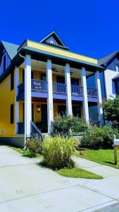a yellow and white building with a porch at Rick's Downtown Nashville Guest House in Nashville