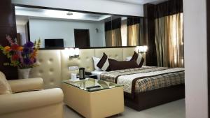 a hotel room with a bed and a chair at Sohi Residency in New Delhi +86 photos