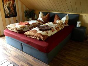 uma cama com almofadas num quarto em Gemütliche Ferienwohnung im Thüringer Wald, nahe des Rennsteigs - pure Erholung em Schmiedefeld am Rennsteig