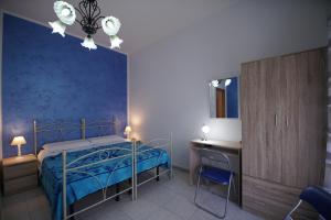 um quarto com uma cama, uma mesa e uma secretária em B&B Nodo Francescano em Porto Empedocle
