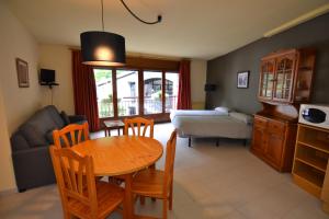 ein Wohnzimmer mit einem Tisch und einem Sofa in der Unterkunft Apartamentos Turisticos Poblado in Arinsal