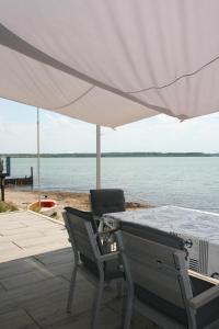 a table and two chairs under a white umbrella at Strandhaus "Knuffeltje" in Rötha