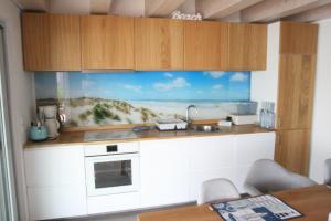 a kitchen with a counter with a view of the ocean at Strandhaus "Knuffeltje" in Rötha +18 photos