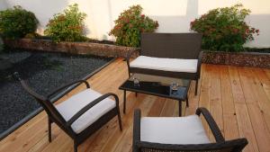 two chairs and a table on a patio with plants at Appartment am Nordpark in Mönchengladbach