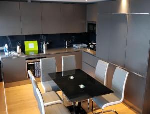 ロンドンにあるAccess Tower Hillのキッチン(黒いテーブル、白い椅子付)