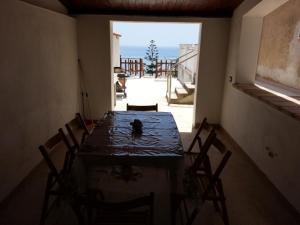 a table with chairs in a room with an open door at Villa Fiorella in Sciacca
