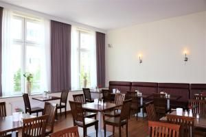 a dining room with tables and chairs and windows at Hotel Hamburg Stadtzentrum in Hamburg