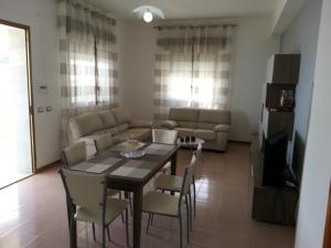 a living room with a table and chairs and a couch at Villa Fiorella in Sciacca