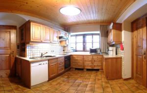 a kitchen with wooden cabinets and a sink and a window at Landgut Gamsleiten in Bad Gastein