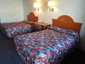 a hotel room with two beds and a desk at Red Carpet Inn Absecon in Galloway