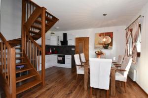 cocina y comedor con mesa de madera y escaleras en Villa Zoja High Tatras, en Stará Lesná