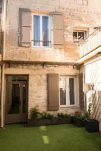 ein Backsteingebäude mit einer Tür und einem Hof in der Unterkunft Les suites du 17 in Aigues-Mortes