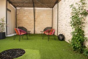 d'une terrasse avec des chaises et une table avec de la pelouse. dans l'établissement Les suites du 17, à Aigues-Mortes