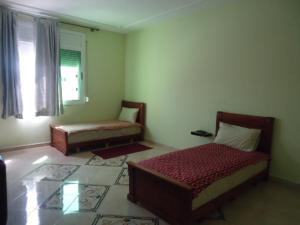 a living room with two beds and a window at Hotel Azul Palace in Sidi Yahia el Gharb