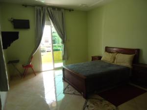 a bedroom with a bed and a sliding glass door at Hotel Azul Palace in Sidi Yahia el Gharb