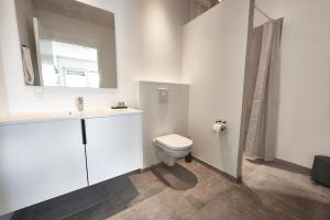 a white bathroom with a toilet and a sink at Hotel Phønix in Holstebro +4 photos
