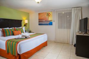 a bedroom with a bed and a flat screen tv at Hotel Tesoro Los Cabos in Cabo San Lucas