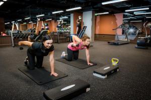 two women doing pushups on mats in a gym at The Address Citywest (formerly Kingswood Hotel) in Citywest