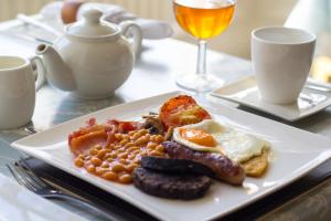 a plate of breakfast food with eggs sausage and beans at Hazeldene Guest House in Perth +78 photos