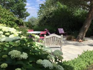 - un jardin avec un banc, une table et des chaises dans l'établissement Chambres d'Hotes au Pays de Valencay en Berry, à Valençay