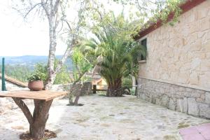 a wooden bench sitting next to a stone wall at Casa Spa en montaña in Pontevedra
