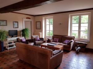 a living room with couches and a table at La Taille de Biou in Huisseau-sur-Cosson