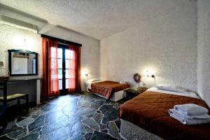a hotel room with two beds and a window at Vagia Beach Apartments, Aegina Island in Vaia