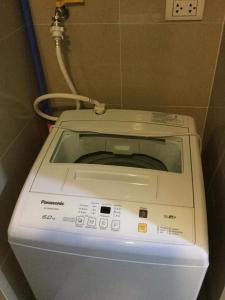 a washing machine in the corner of a bathroom at Palm Tree Villas 2 in Manila