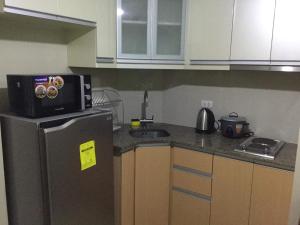 a kitchen with a microwave on top of a refrigerator at Palm Tree Villas 2 in Manila