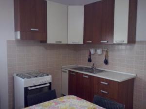 a kitchen with wooden cabinets and a stove and a sink at Villa Punta Grossa 1 in Torre Lapillo +50 photos