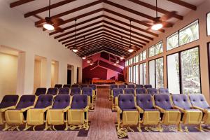 an empty room with blue chairs and large windows at Hotel Jungle Lodge Tikal in Tikal +58 photos