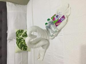 um animal de toalha em forma de cisne com uma garrafa de água em Palm Tree Villas 2 em Manila