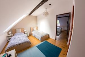 a attic bedroom with two beds and a mirror at Apartamenty Wiakówka in Kazimierz Dolny +24 photos