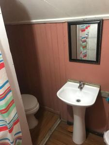 a bathroom with a sink and a toilet and a mirror at Backpacker 644 in Porvenir