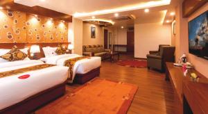 a hotel room with two beds and a living room at Hotel Buddy in Kathmandu
