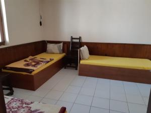 a room with two beds and a chair in it at byala kısta apart in Isperikh